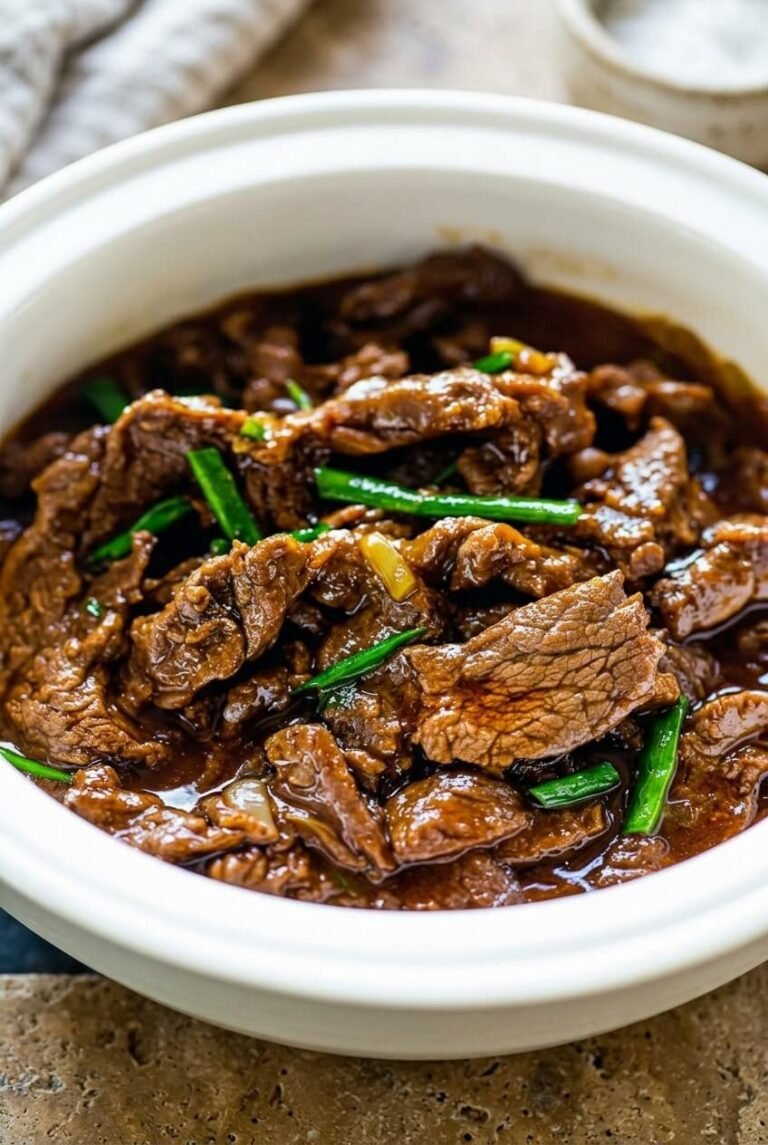 ultimate slow cooker mongolian beef for busy weeknights recipe - Ultimate Slow Cooker Mongolian Beef for Busy Weeknights served in a white bowl overhead view